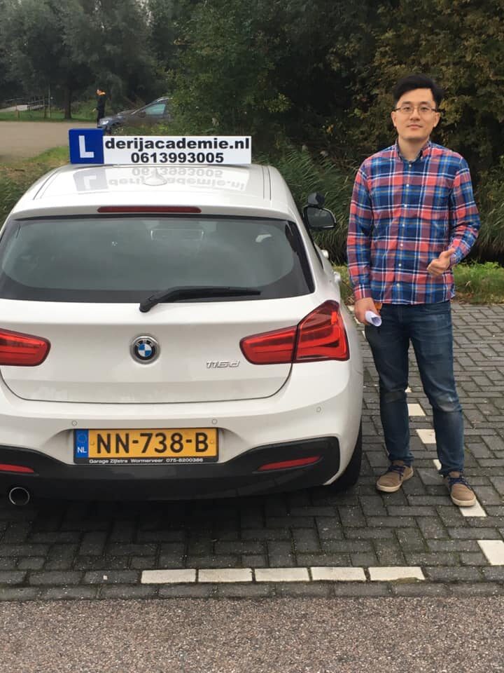 Chen naast de lesauto, net geslaagd